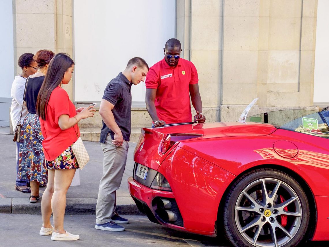 Menschen bei der Begutachtung von einem Ferrari