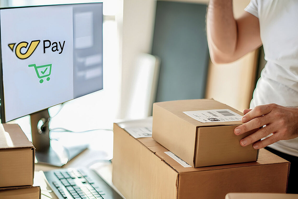 Zwei Pakete vor einem Bildschirm mit dem Post Pay Logo