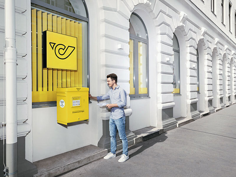 Mann wirft einen Brief in einem Briefkasten