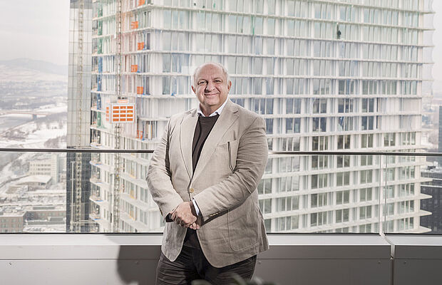 Wolfdieter Jarisch in einem Hochhaus, dahinter der im Bau befindliche DC Tower 2