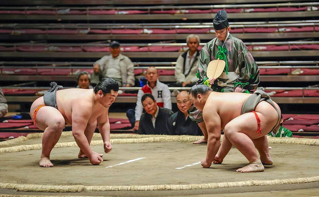 Zwei Sumo-Ringer in Anfangsposition im Ring