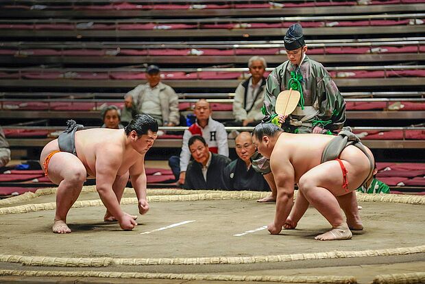 Zwei Sumo-Ringer in Anfangsposition im Ring