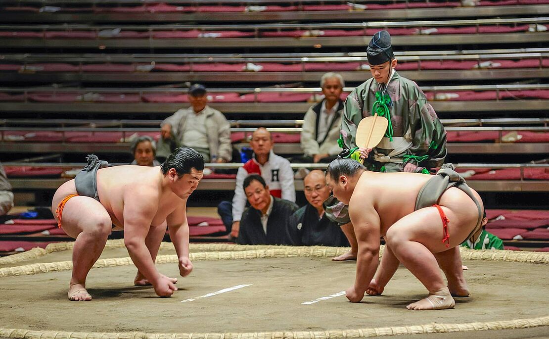 Zwei Sumo-Ringer in Anfangsposition im Ring