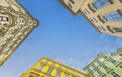 Ein Blick vom Boden aus in den Himmel durch die Häuserschlucht