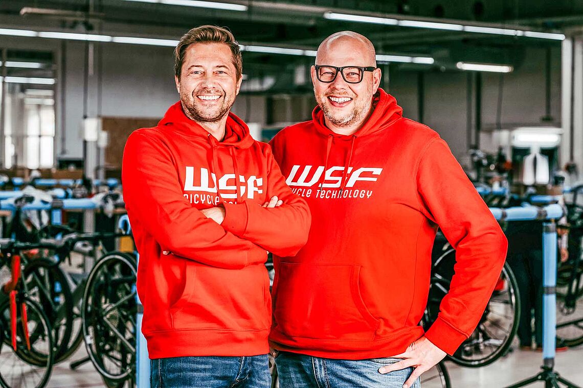 Foto der beiden Männer: Alexander Schnöll (l.) und Roland Wallmannsberger in roten Pullovers