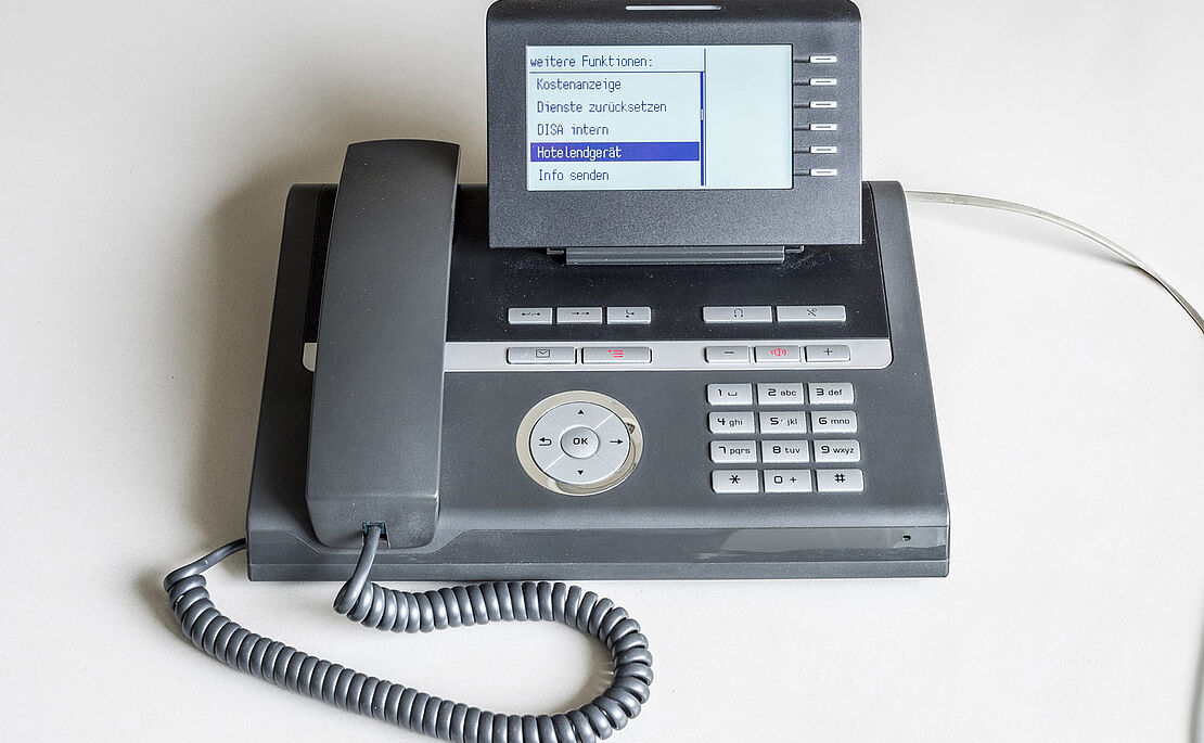 Grauer Telefonapparat mit kleinem Bildschirm