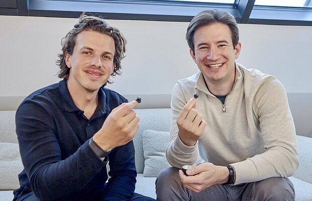 Léon Can Aricioglu und Markus Hirzberger mit je einem Ohrstöpsel in den Fingern