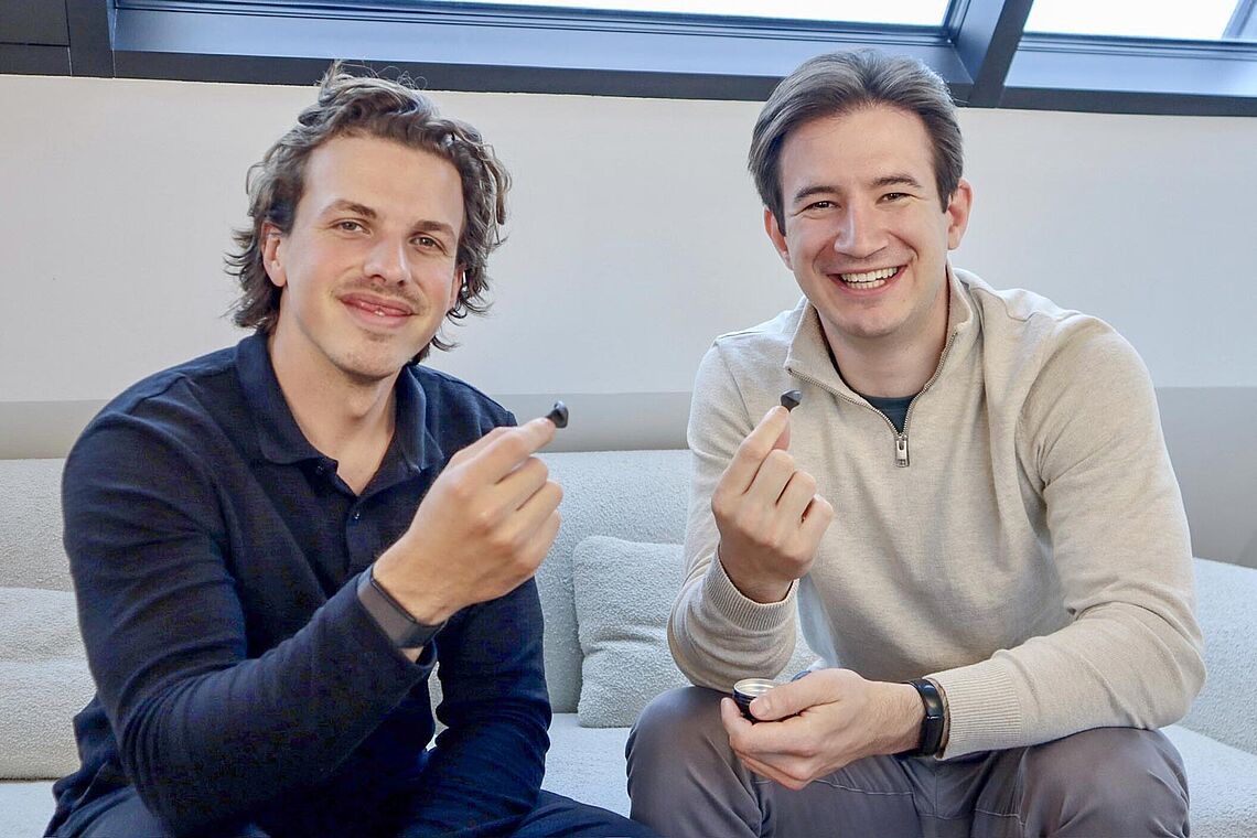 Léon Can Aricioglu und Markus Hirzberger mit je einem Ohrstöpsel in den Fingern