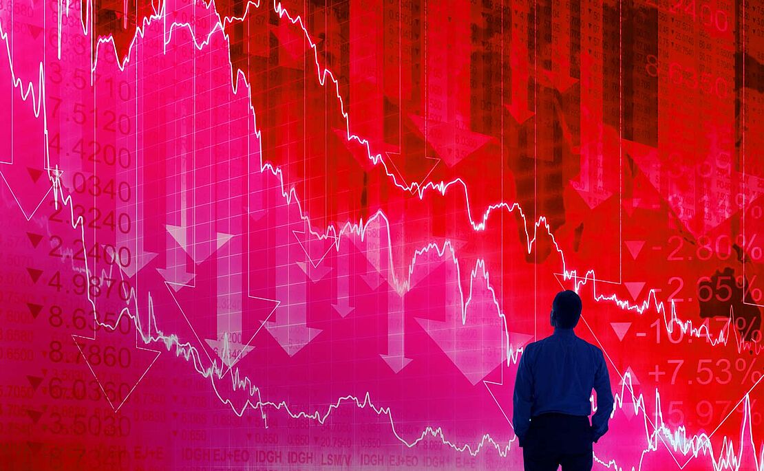 Schatten einen Mannes, der auf eine rote Wand mit fallenden Kursen sieht