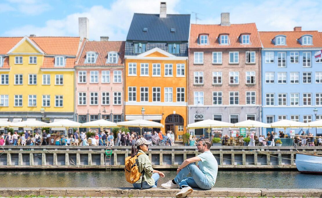 Menschen sitzend am Kanal in Kopenhagen