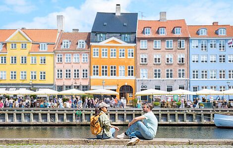 Menschen sitzend am Kanal in Kopenhagen