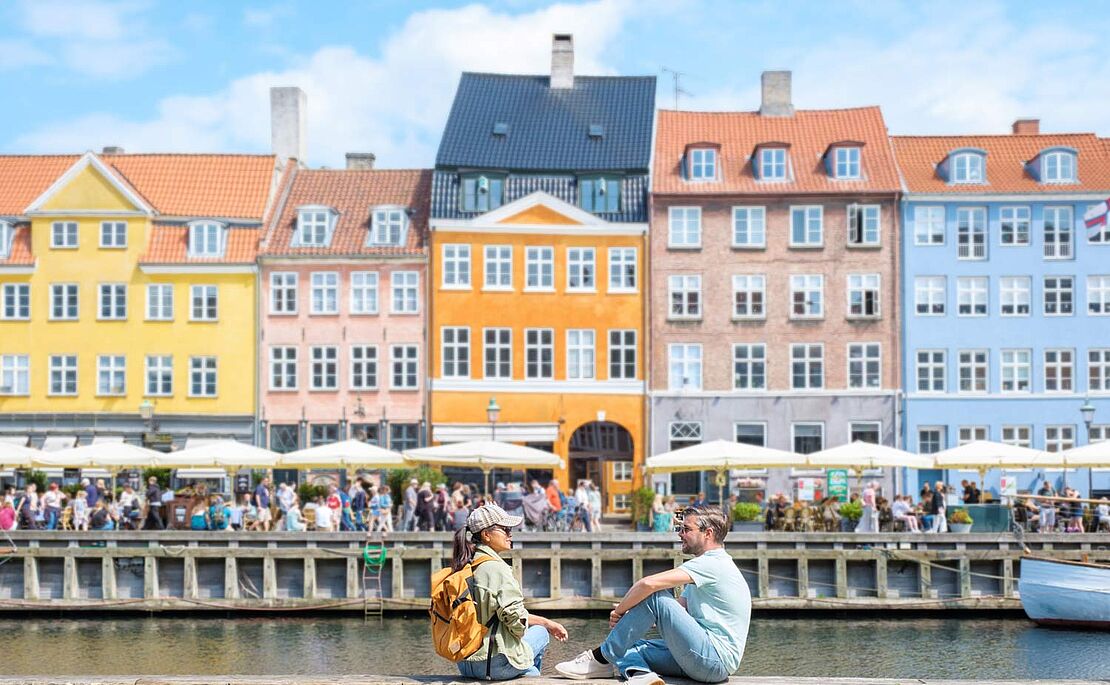 Menschen sitzend am Kanal in Kopenhagen