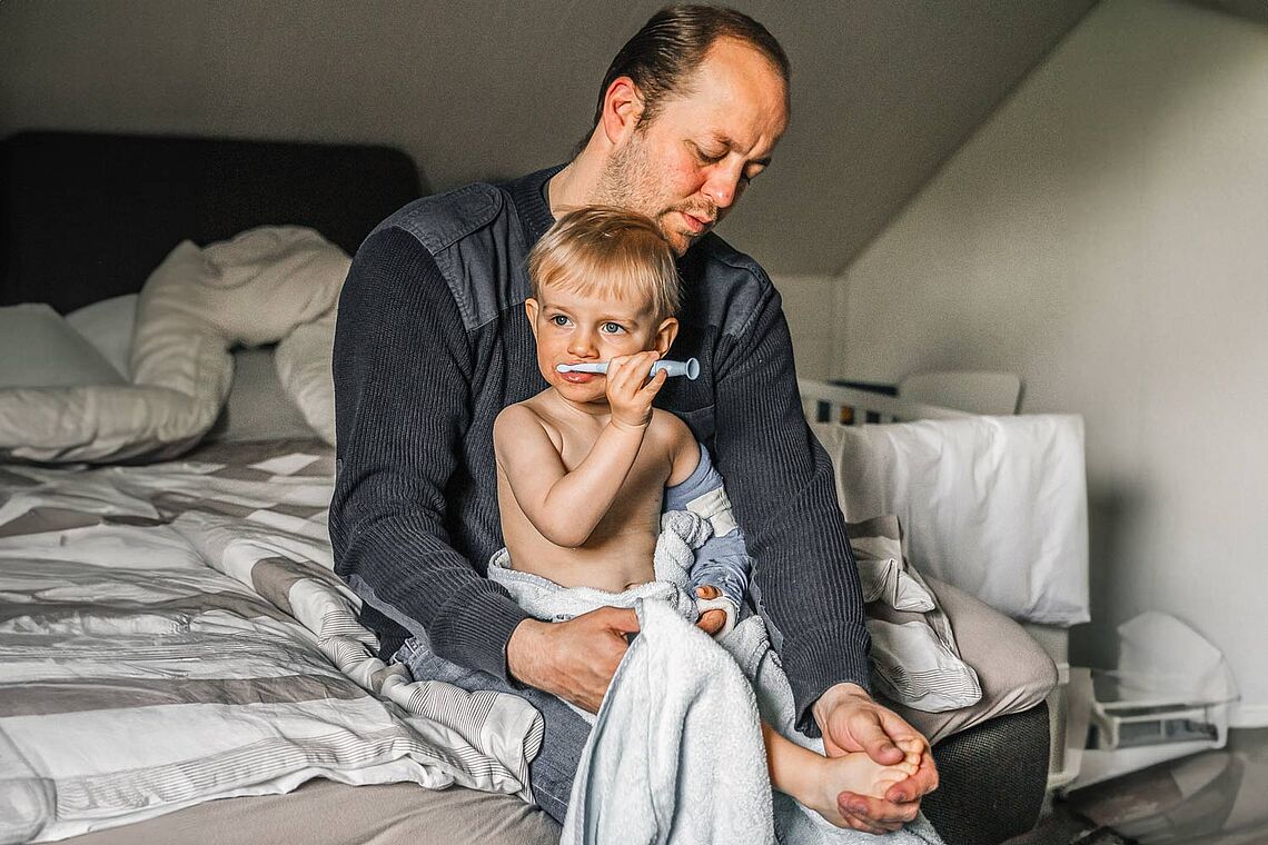 Mann beim Versorgen seines Kindes