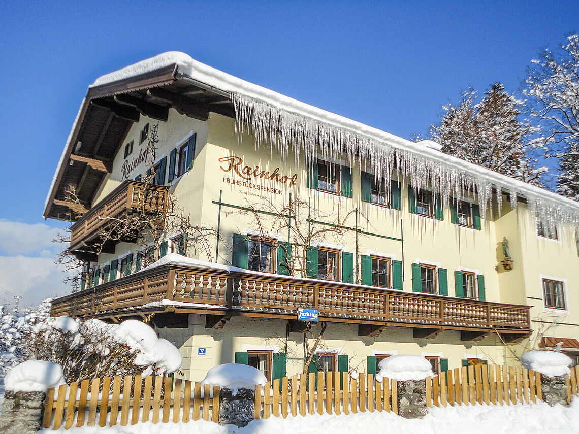 Außenansicht Pension Rainhof im Winter mit Schnee und Eiszapfen vom Dach