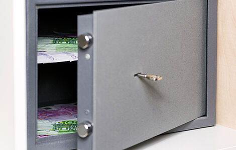 Geöffneter Safe, darin Geldbündel
