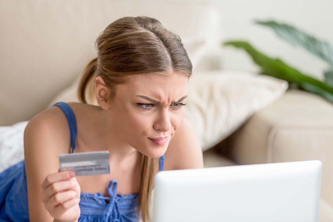 Frau mit Kreditkarte vor Laptop