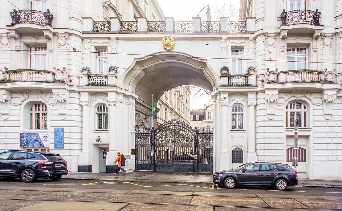 Zwei Zinshäuser, mit einem Durchgang verbunden, darauf eine Terrasse, im Durchgang ein schmiedeeisernes Tor