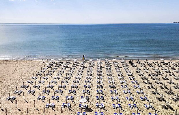 Meer und großer Strand mit hunderten von Liegen und Sonnenschirmen