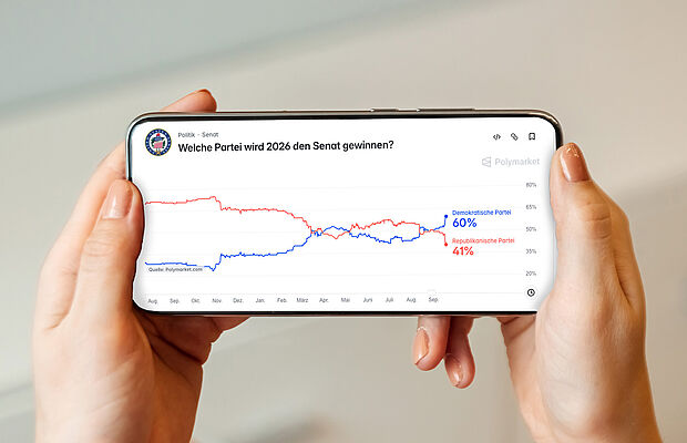 Bildschirm eines Handys, das von Frauenhänden gehalten wird, darauf ein Chart, wer die Midterms in den USA gewinnen wird