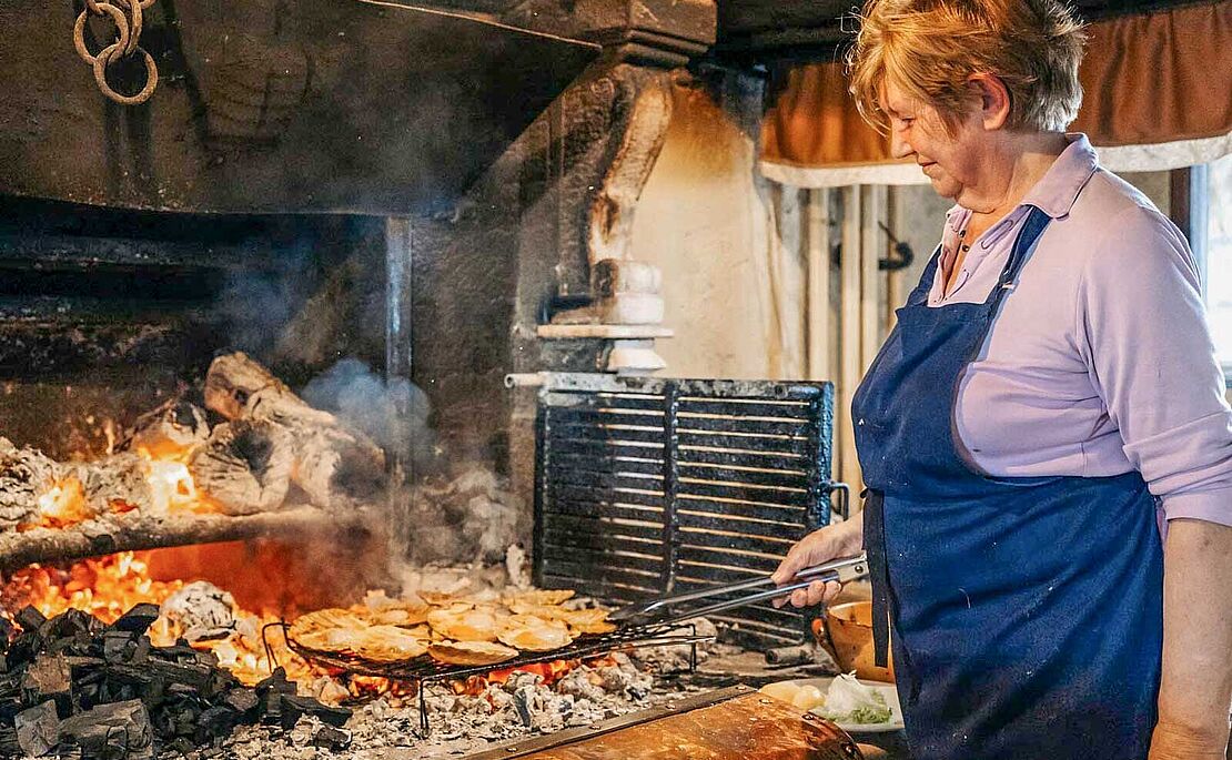 Köchin kocht am offenen Feuer in der Konoba Astarea in Brtonigla
