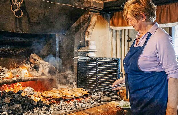 Köchin kocht am offenen Feuer in der Konoba Astarea in Brtonigla