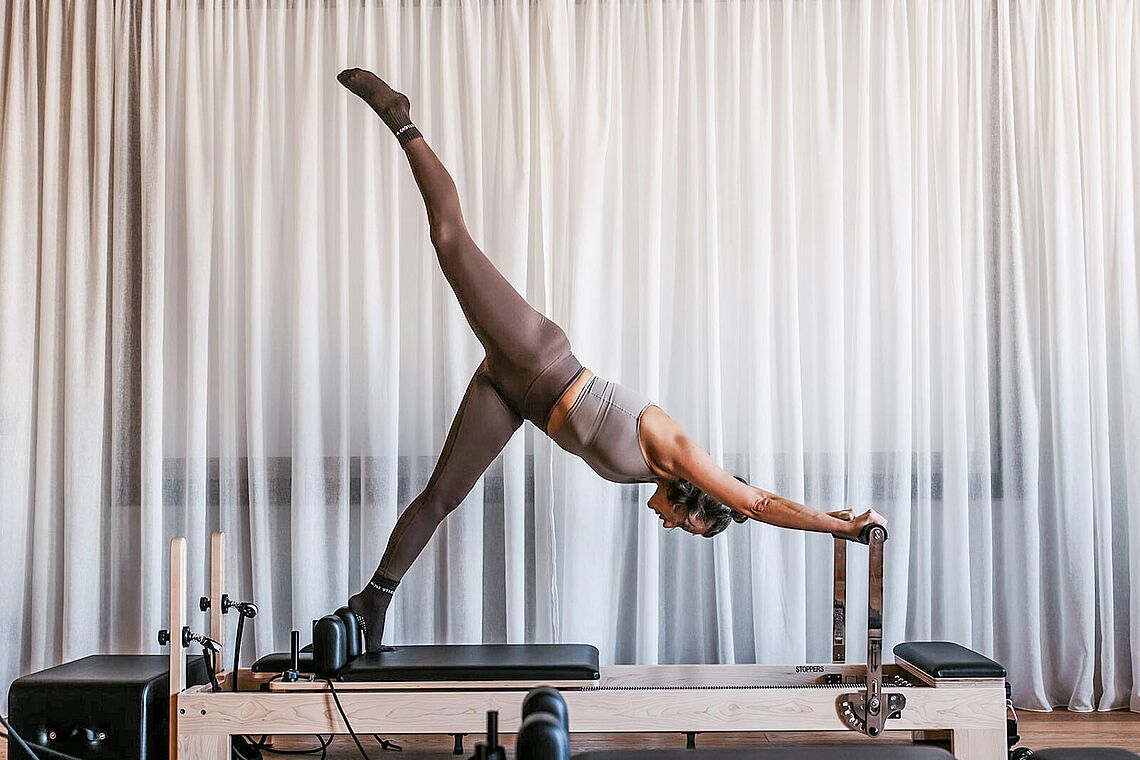 Frau bei Reformer Pilates im Hotel Alpina Alpendorf