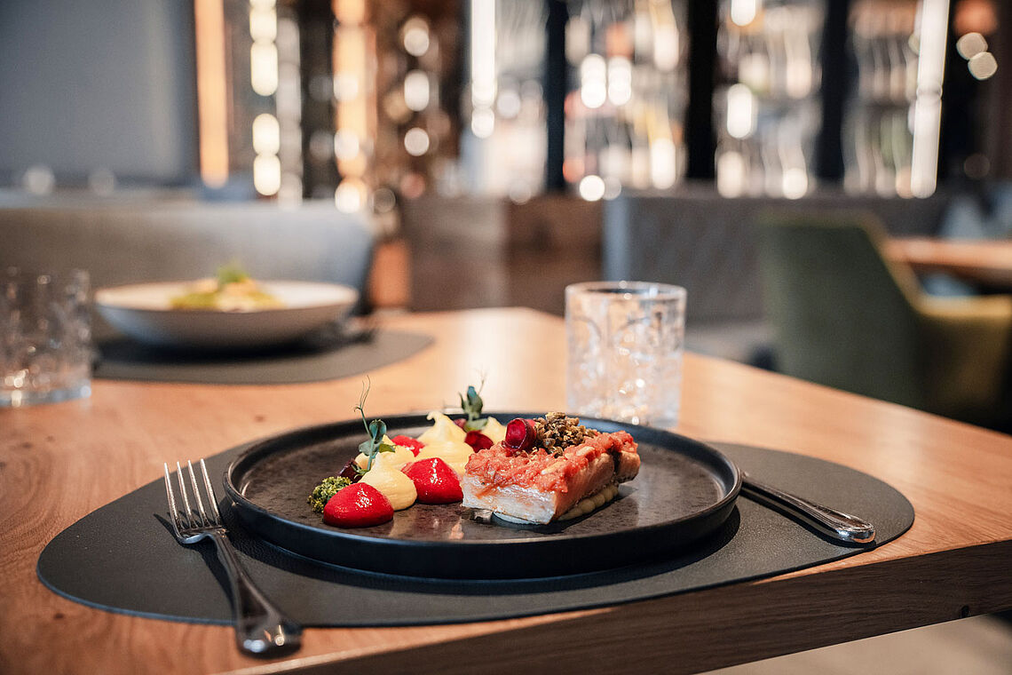 Tisch mit Teller mit Fleisch und Gemüse im Hotel Kesselgrub