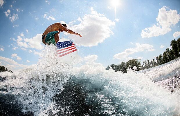 Wellenreiter auf einem Surfbrett mit USA Flagge