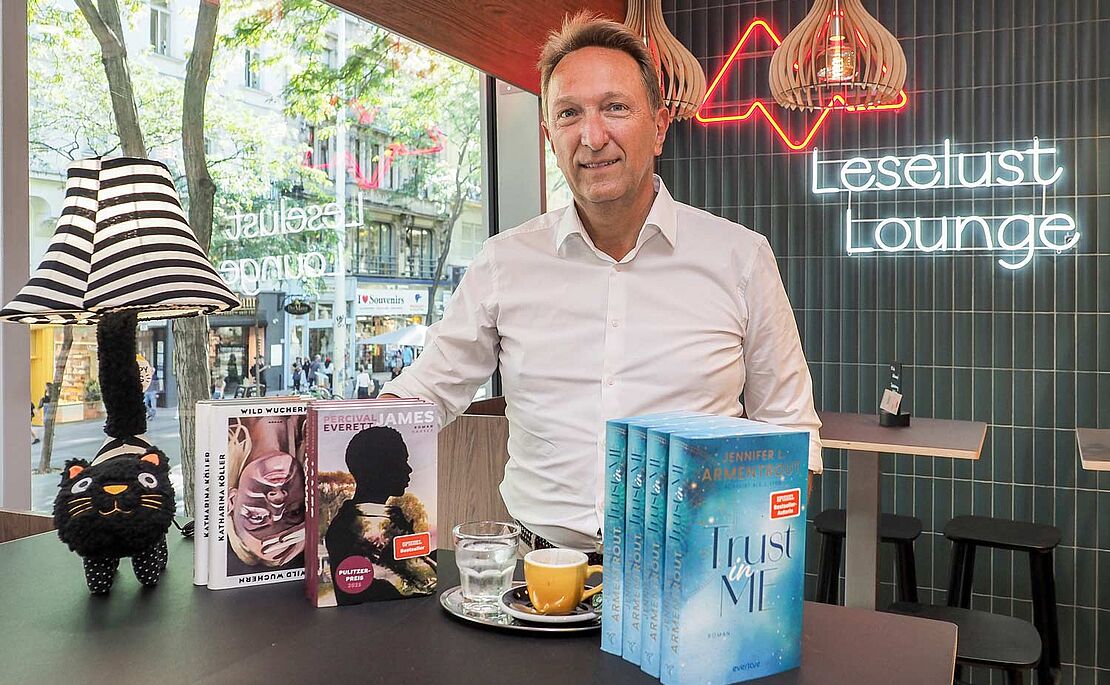 Klaus Magele in der Leselust Lounge mit Büchern und Kaffe vor ihm