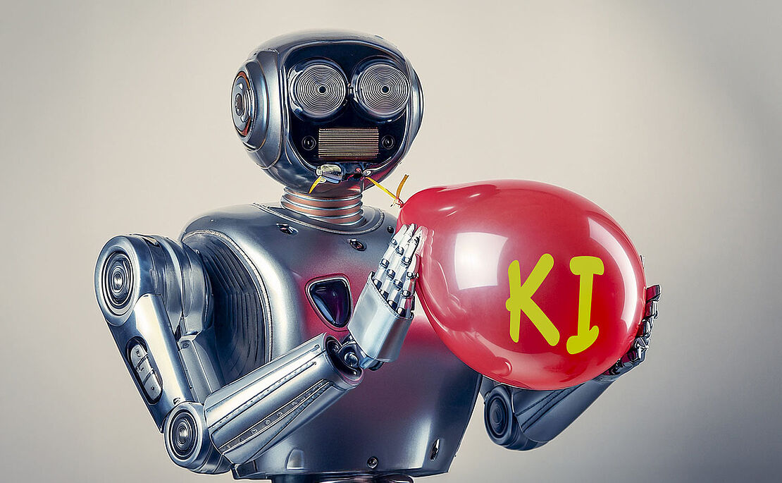 Rolboter, der einen roten Luftballon mit der Aufschrift KI aufbläst