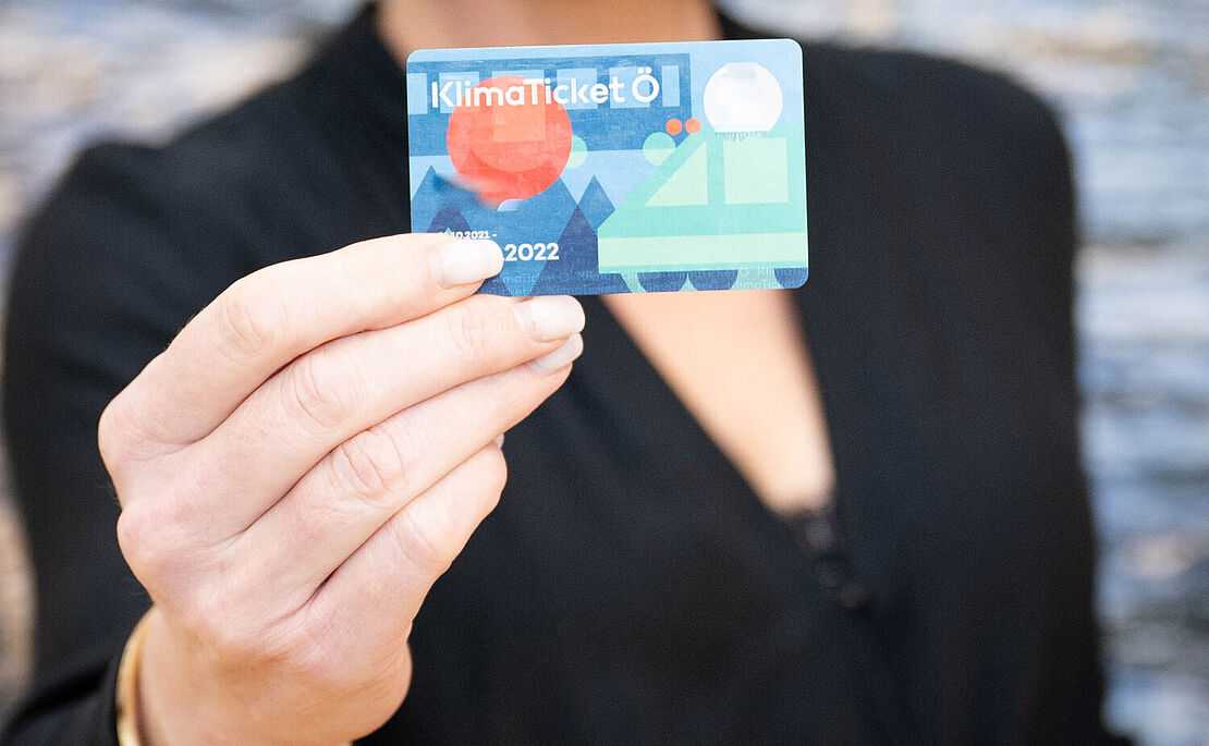Frau zeigt ein Klimaticket