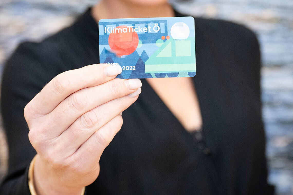 Frau zeigt ein Klimaticket