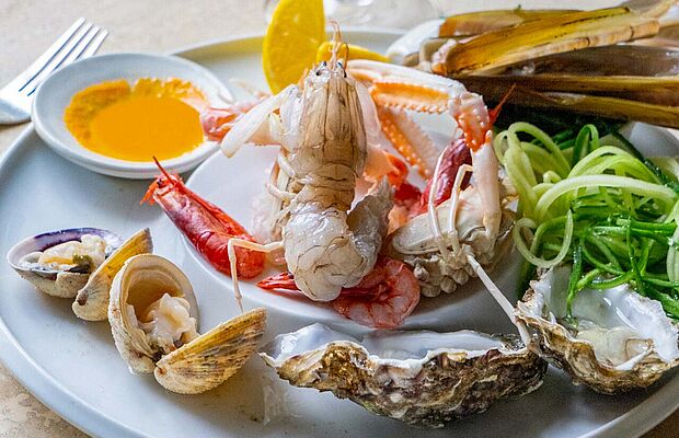 Fischkreation mit Krabbe und Muscheln auf Teller