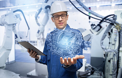 Mann mit Blaumann und weißem Helm hält Hand unter visulisierten Motor