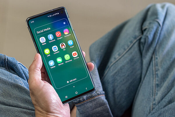 Person hält ein Handy mit einem Computerchip von Tencent in der Hand