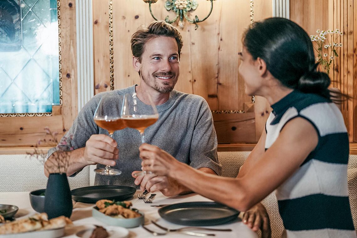 Frau und Mann beim Abendessen in der Zirbenstube Hotel Alpina Alpendorf