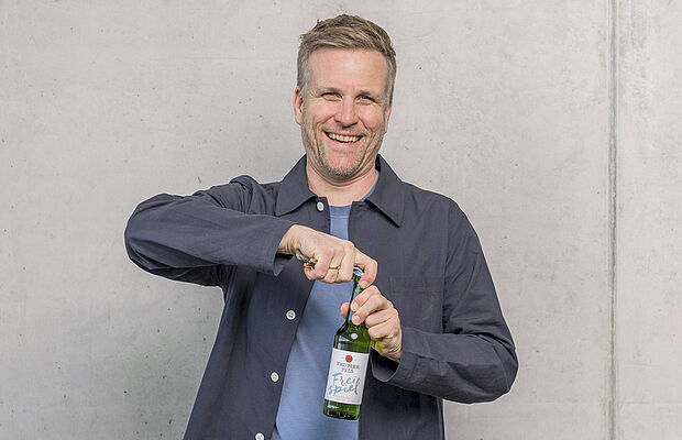 Josef Sigl beim Öffnen eines Trumer Pils