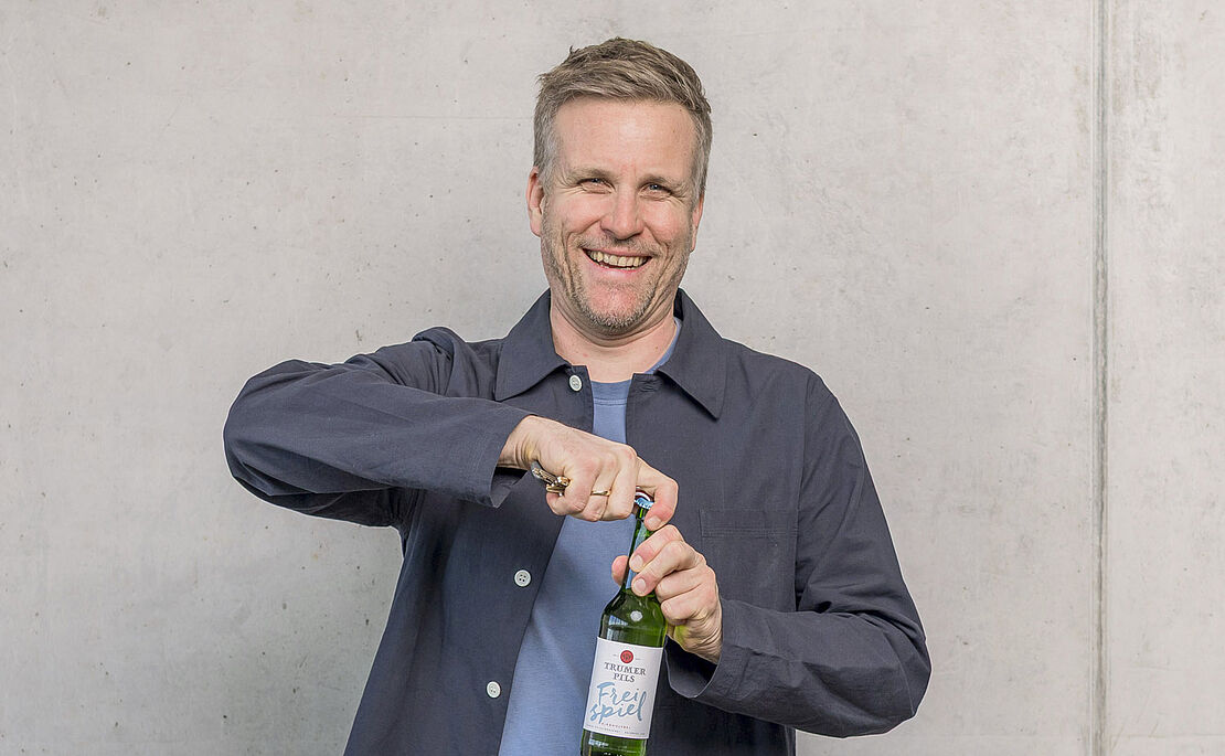 Josef Sigl beim Öffnen eines Trumer Pils