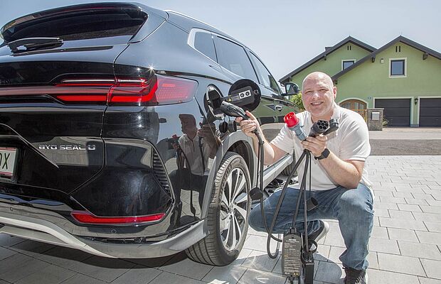 Markus Schellner kniend vor seinem Auto