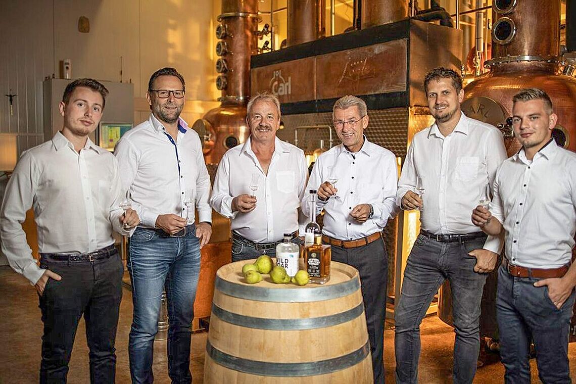 Sechs Männer mit Schnapsgläsern bei einer Schnapsverkostung in der Destillerie Puchas