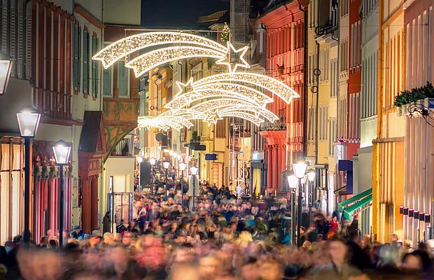 Blick auf eine gefüllte Einkaufsstraße mit Weihnachtsbeleuchtung