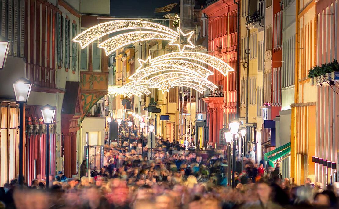 Blick auf eine gefüllte Einkaufsstraße mit Weihnachtsbeleuchtung