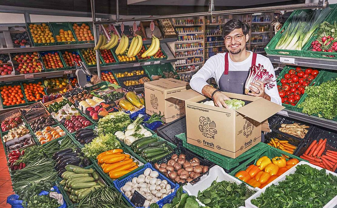 Mann, der Obst in Kiste packt