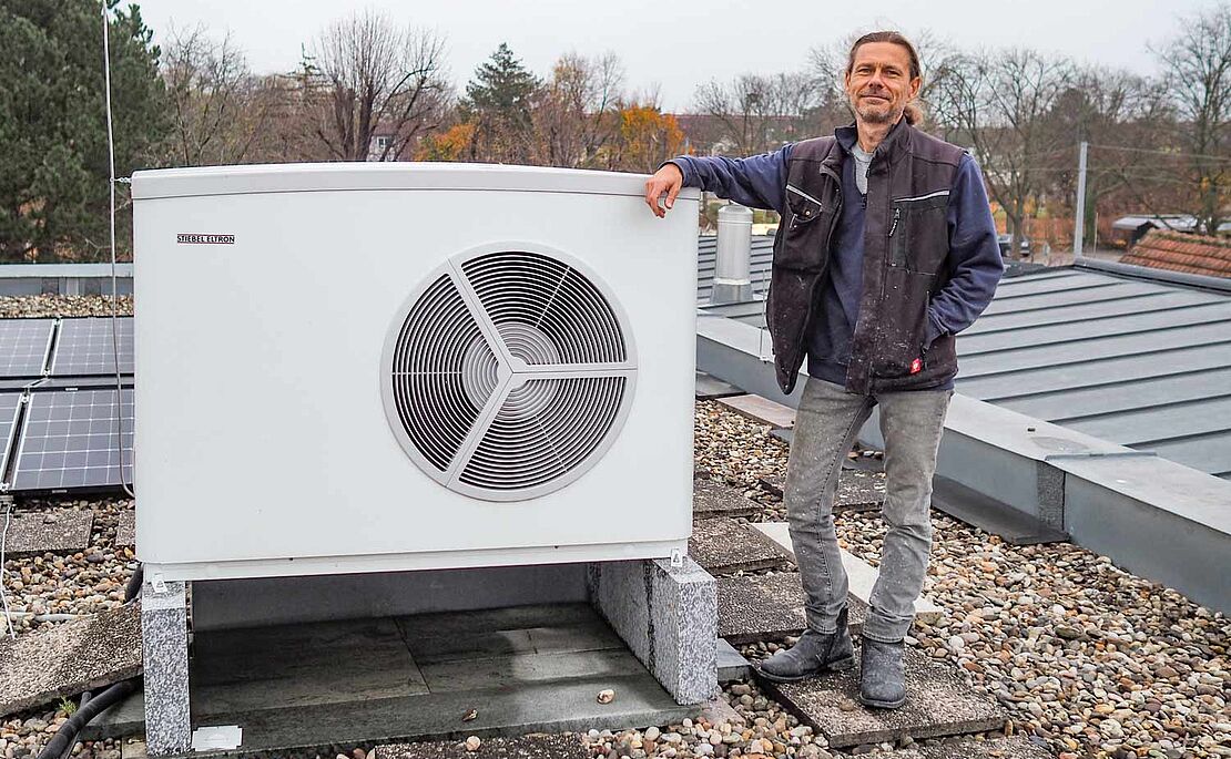 Steinmetz Markus Peche mit seiner Wärmepumpe am Dach