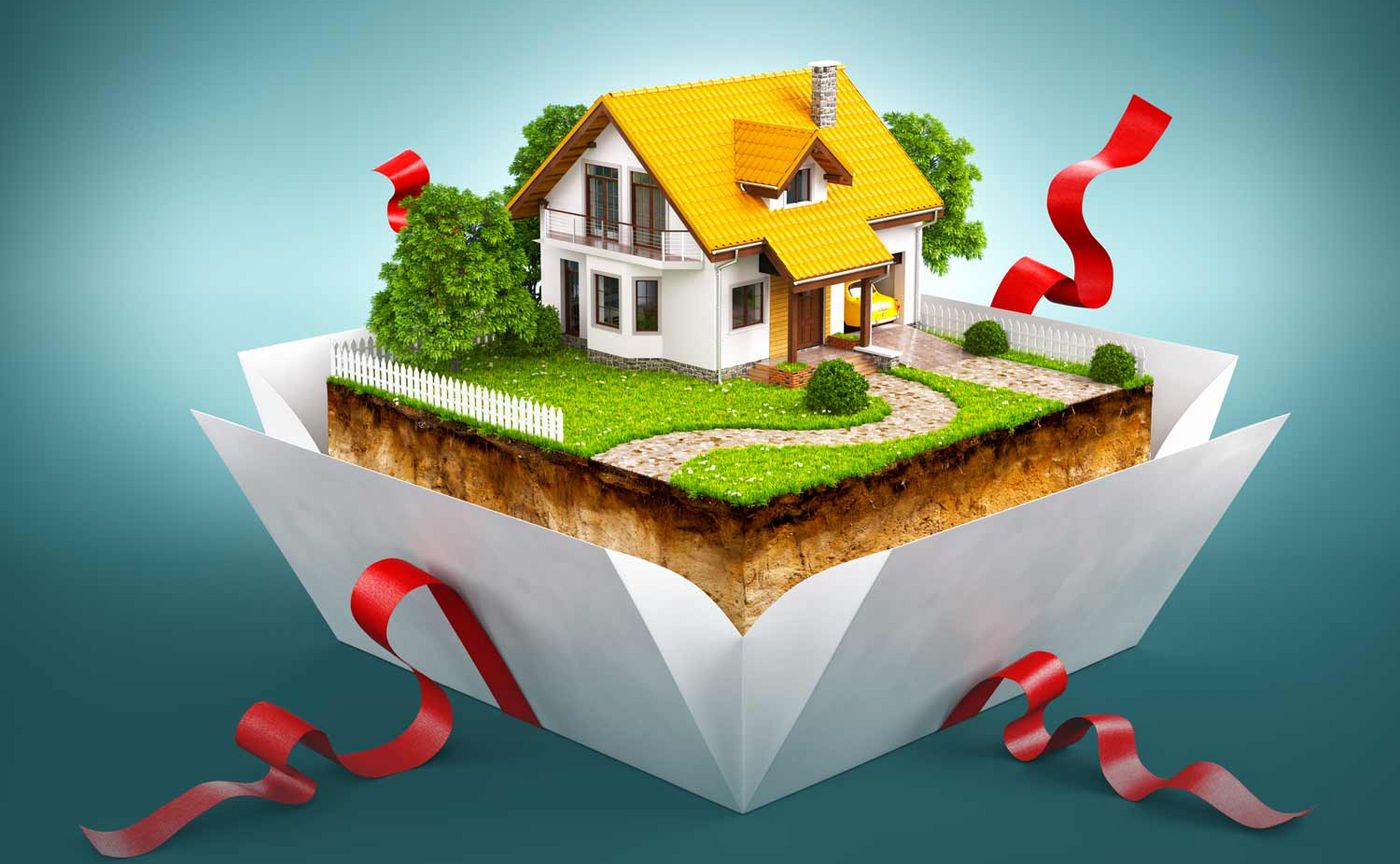 Geschenkbox mit einem Haus auf einem Stück Erde mit Gras und Baum