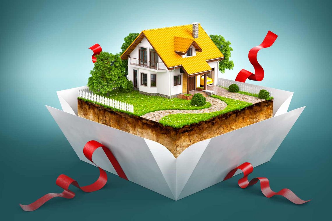 Geschenkbox mit einem Haus auf einem Stück Erde mit Gras und Baum