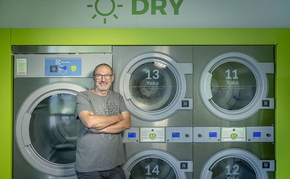 Reinhold Draxler vor seinen Industriewaschmaschinen