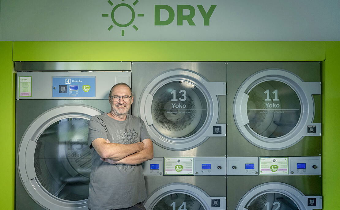 Reinhold Draxler vor seinen Industriewaschmaschinen