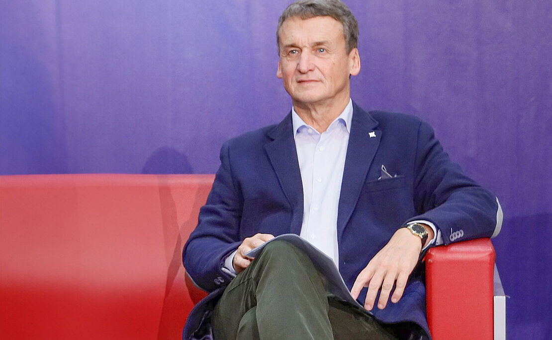 Erich Pitak auf roter Couch