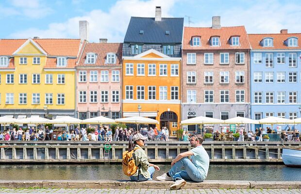 Zwei Menschen sitzen am Hafen in Dänemark